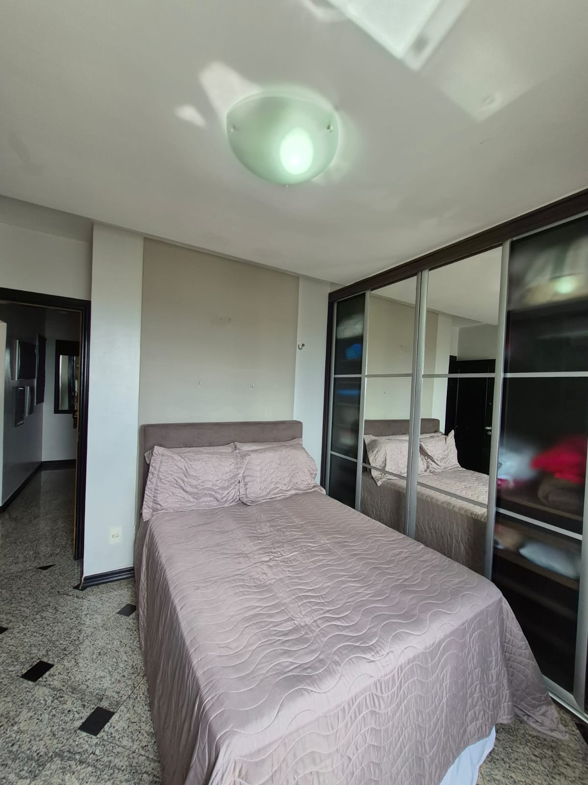 Suíte com armários modulados e piso em granito