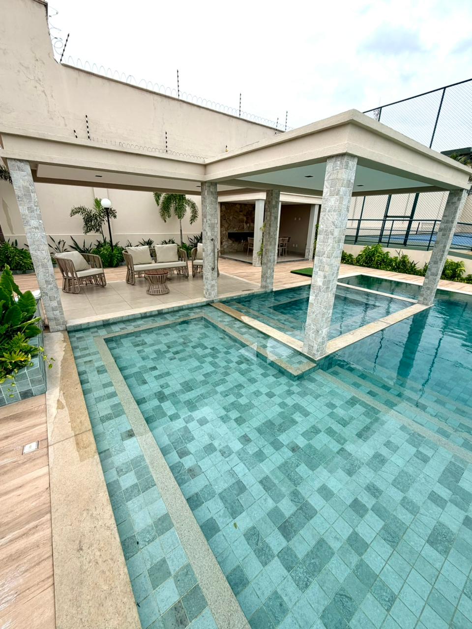 Espaço gourmet coberto com churrasqueira à beira da piscina